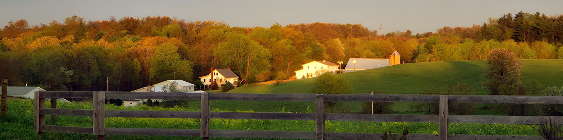 A view of some houses in the distance from behind a fence.