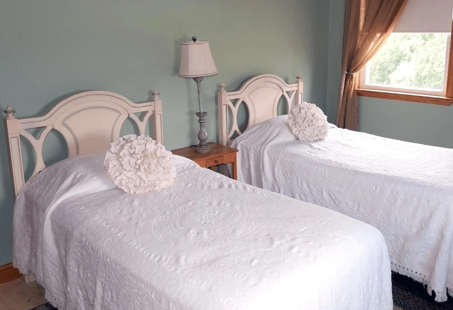 Two twin beds in a bedroom with white sheets and pillows.