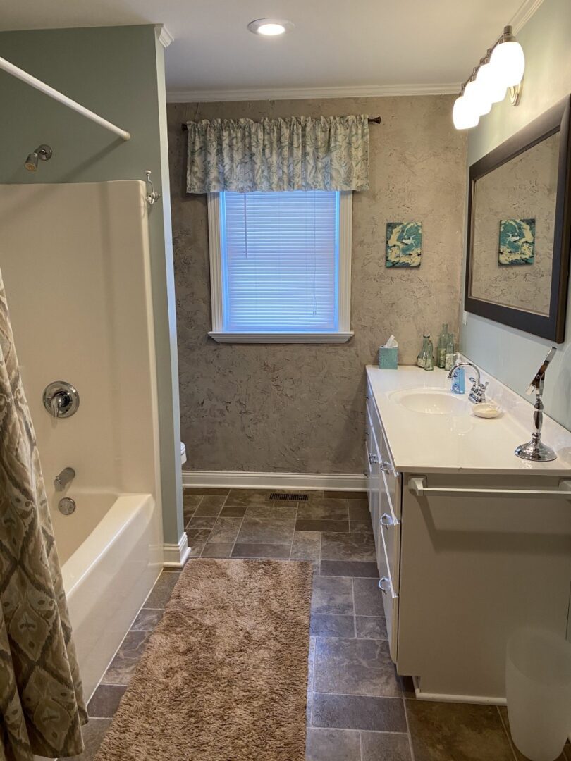 A bathroom with a sink, mirror and tub.
